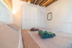 基奥贾Casetta Stretta Bersaglio的卧室配有带毛巾的床,位于地面。