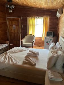 凯麦尔Oran Ağaç Bungalovs的一间卧室配有一张大床和毛巾