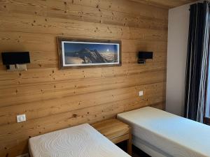 瓦洛西讷Large premium alpine apartment for 4 to 8 people的一间设有两张床的客房,墙上挂着一张照片