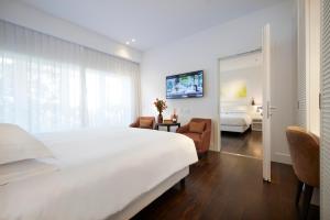 米兰Magna Pars l'Hotel à Parfum, Small Luxury Hotels of the World的酒店客房设有一张白色大床和电视。