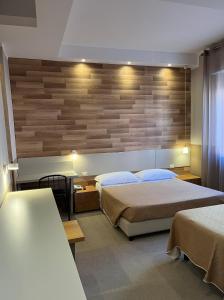 利沃诺欧罗巴派金酒店的一间卧室设有两张床和木墙