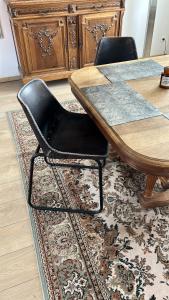 图尔昆Haylenes的一张桌子,上面有两把黑色椅子,坐在地毯上