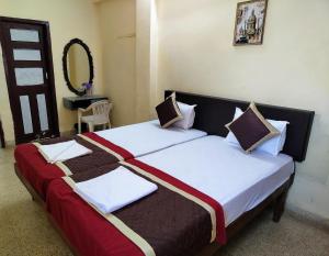 波戈马洛Sea View Resorts的一间卧室配有两张带白色和棕色床单的床
