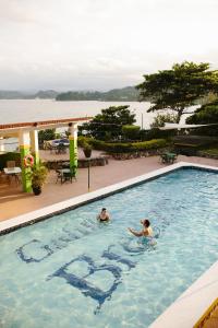 Port Maria加林娜微风酒店的两人在游泳池游泳,并使用Spa