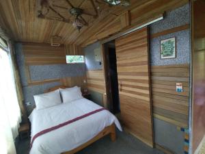 帕帕亚克塔Mamallacta Páramo Lodge的木制客房内的一间卧室,配有一张床