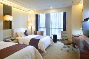襄阳襄阳富力皇冠假日酒店 的酒店客房设有两张床和电视。