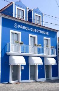 英雄港Farol Guesthouse的蓝色和白色的建筑,设有白色阳台