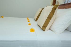 高尔Greenway Apartment的一张带白色枕头和黄色鲜花的床