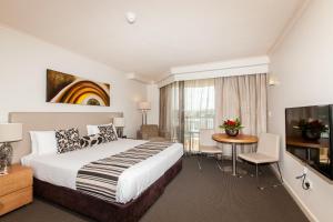 布里斯班科斯莫中央公寓酒店的酒店客房设有床、桌子和电视。