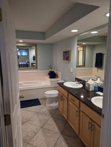 比洛克西Biloxi Beach Condo-B的一间带两个盥洗盆、浴缸和卫生间的浴室