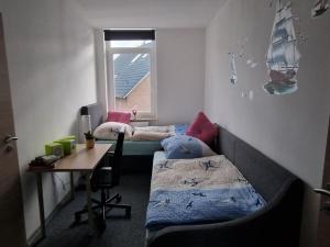 不来梅港Küstenliebe的客房设有两张床、一张桌子和一个窗户。