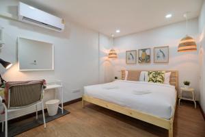 曼谷Bangkok Watergate Townhouse 曼谷中心水門家的卧室配有一张白色大床和一张书桌
