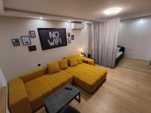 采列KELEIA NEW VILLAGE的客厅配有黄色沙发,没有WiFi标志
