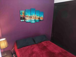 马德里Precioso piso en la playa de Madrid a 45 min del centro de la ciudad的一间卧室配有一张紫色墙壁的床