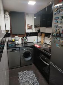 马德里Precioso piso en la playa de Madrid a 45 min del centro de la ciudad的厨房配有洗衣机和冰箱。