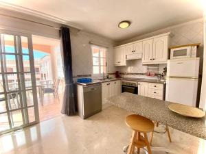 卡亚俄萨尔瓦赫Superior Apartment with Ocean View的厨房配有白色橱柜和带桌子的柜台。
