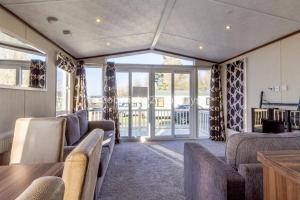 大雅茅斯Luxury Caravan Nearby The Beautiful Scratby Beach In Norfolk Ref 50001a的带沙发、桌子和窗户的客厅