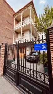 第比利斯Marmenio Hotel - Tbilisi的一座有蓝色标志的房子前的大门