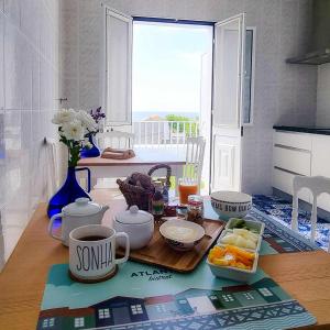 英雄港Farol Guesthouse的一张桌子,上面放着一盘食物和一杯咖啡