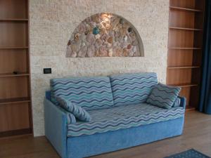 San SabaAppartamenti Sole Mare - Affitto minimo settimanale - Weekly minimum rent的石头墙房里的蓝色沙发