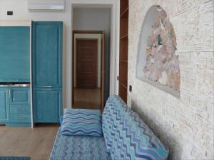 San SabaAppartamenti Sole Mare - Affitto minimo settimanale - Weekly minimum rent的客厅设有蓝色的沙发和石墙