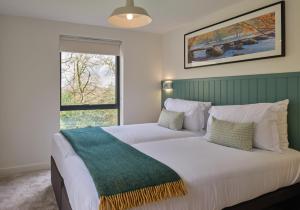 ChittlehamholtThe Mole Resort - Lodges的卧室配有一张大白色床和窗户