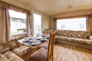 大雅茅斯8 Berth Caravan At California Cliffs Holiday Park In Norfolk Ref 50007d的一间带桌子和沙发的用餐室