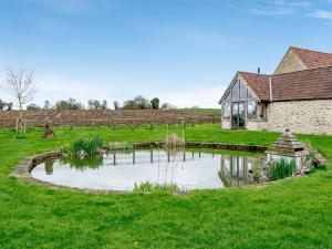 贝克因顿Pears Cottage - Uk43674的房子旁边的田野里的池塘