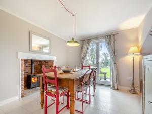 贝克因顿Pears Cottage - Uk43674的一间带桌椅和壁炉的用餐室
