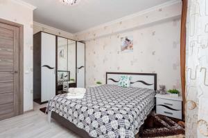 阿拉木图Светлая квартира рядом с парком Горького的一间卧室配有一张带黑白色棉被的床