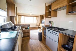 大雅茅斯Lovely 6 Berth Caravan With Decking For Hire In Norfolk Ref 50026k的厨房配有炉灶和台面