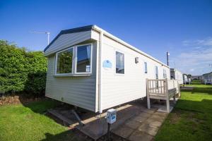 大雅茅斯Lovely 6 Berth Caravan With Decking For Hire In Norfolk Ref 50026k的院子里有门廊的小白色拖车