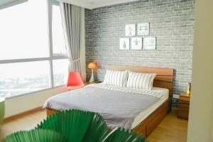 胡志明市Liam Service Apartment - Vinhome Central Park的一间卧室设有一张床和砖墙