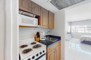 迈阿密海滩Decoplage Paradise - Unit A的厨房配有炉灶和微波炉。