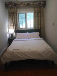 TottenhamConservation lands family suite 2 rooms的卧室内的一张大床,设有窗户