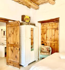 艾伯特王子镇Brakdakkie Guest Cottages的一间卧室配有一张床、一扇门和一把椅子