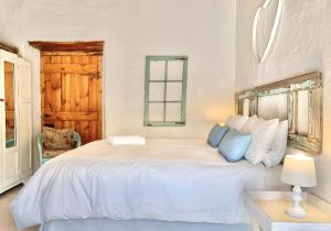 艾伯特王子镇Brakdakkie Guest Cottages的白色卧室配有白色大床和蓝色枕头