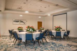 劳德代尔堡Maritime Hotel Fort Lauderdale Airport & Cruiseport的一间设有桌椅和鲜花的会议室