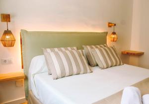 桑帕克Beach Club Menorca的一间卧室配有一张带两个枕头的床