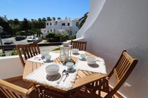 阿尔布费拉São Rafael Beach Apartment 92A, Albufeira - Algarve的阳台上的木桌,带盘子和杯子