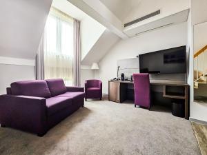 杜塞尔多夫Valemi Stay - Selfservice的客厅配有紫色沙发和电视