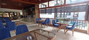 凯麦尔Orange Garden Hotel的阳台餐厅设有蓝色的桌椅