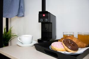 卡沃斯Big Max Guesthouse的柜台盘上的两个甜甜圈,上面有咖啡和饮料