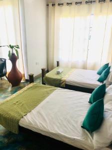 康提Barefoot Inn Kandy的两张带绿色枕头的床