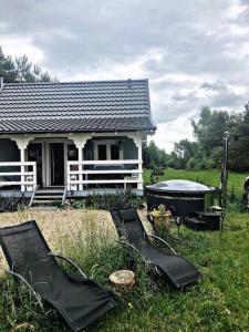 Stara KiszewaOaza spokoju w lesie的前面有两把草坪椅的房子
