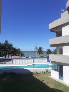 皮乌马Apartamento 204 vista para o mar e piscina的享有大楼旁游泳池的景色