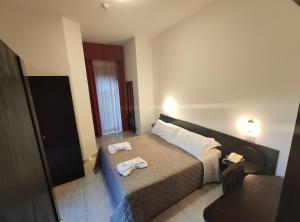 里米尼梅莫里酒店的一间卧室配有一张床,上面有两条毛巾