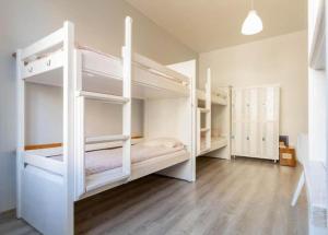 索波特Vibe Hostel Sopot的一间设有两张白色双层床的房间