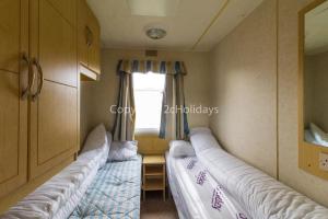 大雅茅斯8 Berth Caravan At California Cliffs Holiday Park In Norfolk Ref 50007d的带窗户的客房内的两张床