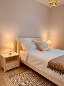 卡特勒博尔纳Home Sweet Home的一间卧室配有一张床和一个带两盏灯的床头柜。
